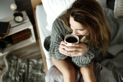 Woman holding coffee cup at home