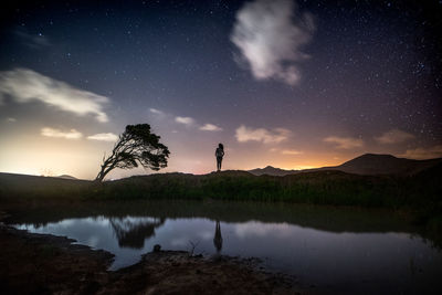 Scenic view of lake against sky at night