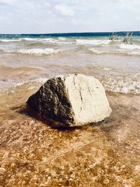 Scenic view of rocks on beach against sky