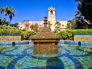 Fountain in swimming pool against clear blue sky