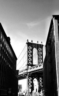 Low angle view of bridge in city against sky