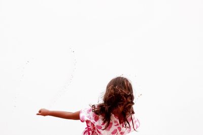 Low angle view of woman with tousled hair against clear sky