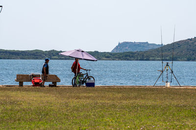 People on beach against clear sky