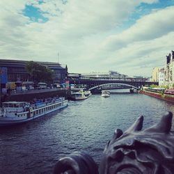 Bridge over river against cloudy sky