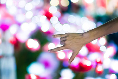 Close-up of woman hand reaching at night