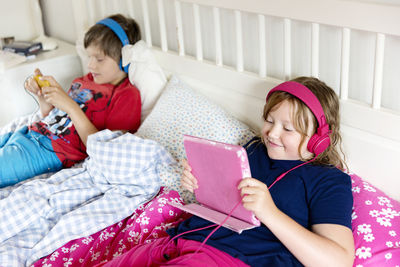 Brother and sister using wireless devices