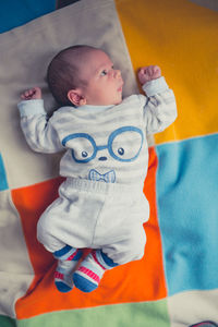 High angle view of baby lying on sofa