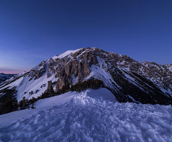 Scenic view of snowcapped mountains against clear blue sky