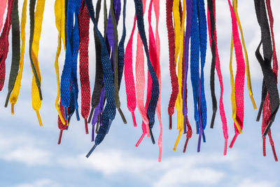 Low angle view of multi colored straws against blue sky