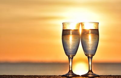 Close-up of wine glass against sunset