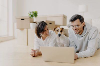 Smiling couple using laptop at home