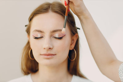 Close-up of young woman with long hair against white background