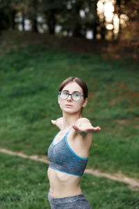 The relaxed girl is doing yoga in the park on carpet