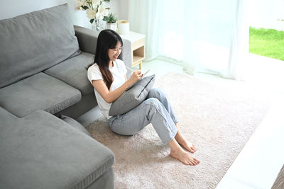 Young woman sitting on sofa at home