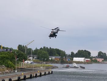 Airplane flying over river against sky