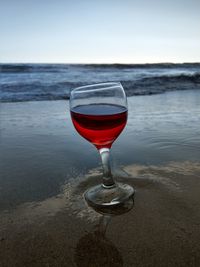 Red wine glass on beach