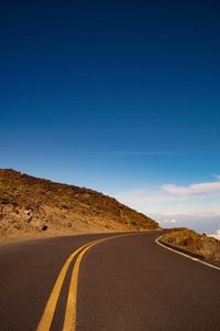 Empty road against blue sky