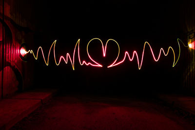 Illuminated light painting on wall at night