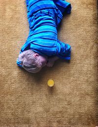 High angle view of boy relaxing on carpet