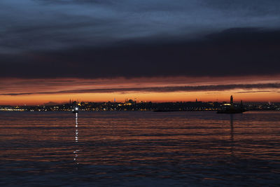 Scenic view of sea against dramatic sky during sunset