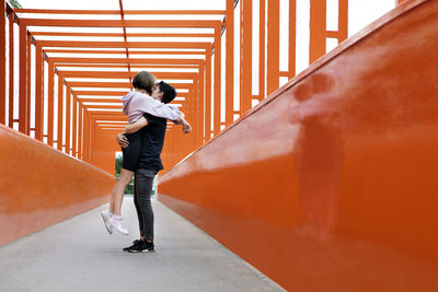 Teenage couple kissing on orange bridge
