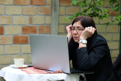 Man using mobile phone while sitting on table