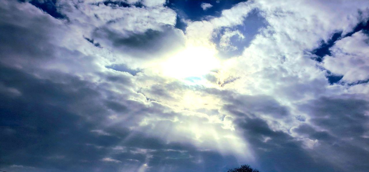 sky, cloud, beauty in nature, low angle view, sunlight, nature, scenics - nature, sunbeam, cloudscape, dramatic sky, daytime, no people, tranquility, outdoors, tranquil scene, environment, sun, blue, idyllic, backgrounds, day, overcast, storm, horizon, tree, awe, moody sky