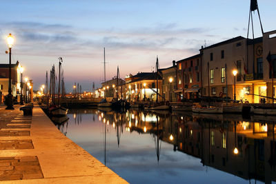 Boats moored at harbor during sunset