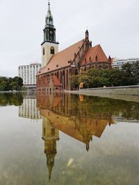 Reflection of building in lake against sky