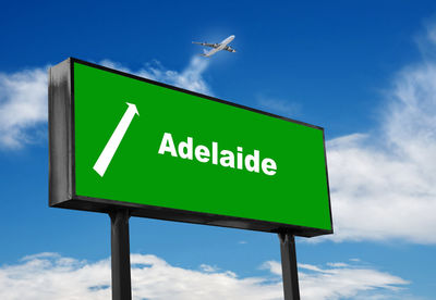 Low angle view of road sign against blue sky