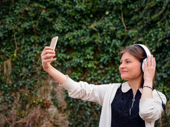 Young woman photographing with mobile phone