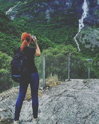 Rear view of woman photographing on mobile phone