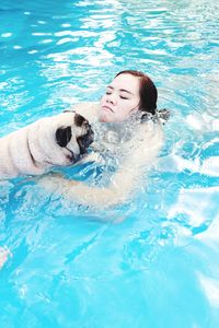 Woman with dog swimming in pool