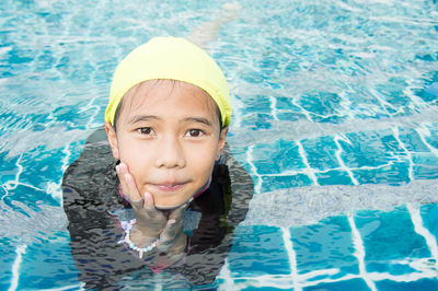 High angle portrait of smiling girl swimming in pool