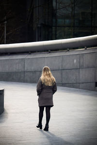 Rear view of woman walking on footpath