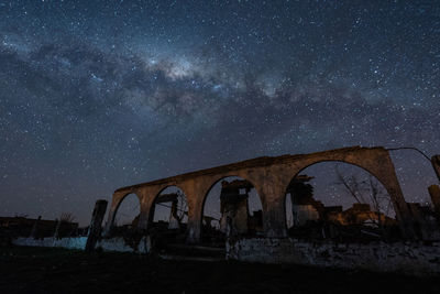 Arch bridge against sky at night