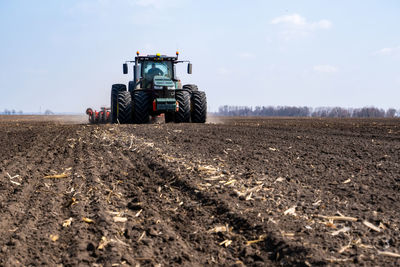 Tractor on agricultural field against sky