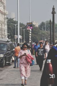 Rear view of women walking on street in city