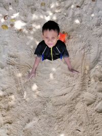 High angle view of boy playing on sand