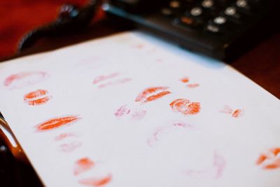 High angle view of paper with lipstick mark on table