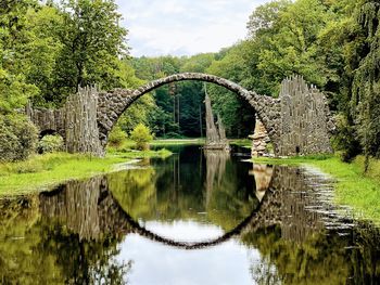 Arch bridge over lake against sky