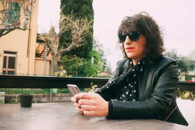 Woman using mobile phone at outdoor cafe