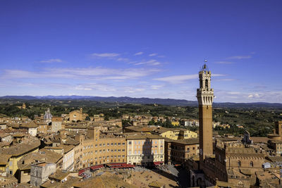 Aerial view of siena from facciatone - torre del mangia and red tiled traditional rooftops