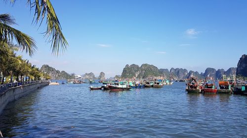 Boats sailing on sea against blue sky