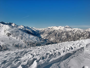 Scenic view of snowcapped mountains against blue sky