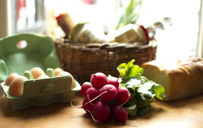 Radishes with eggs by bread on table at home