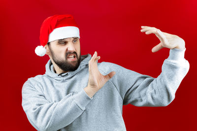 Midsection of man wearing hat against red background