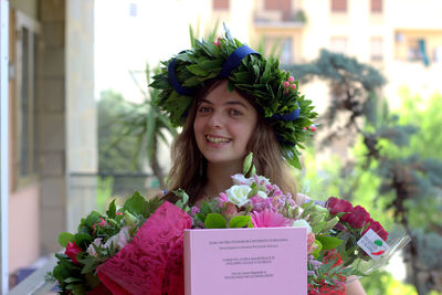 Portrait of young woman holding bouquet