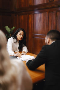 Confident female lawyer discussing over contract with colleague in board room meeting