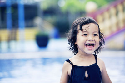Happy girl looking away while swimming in pool